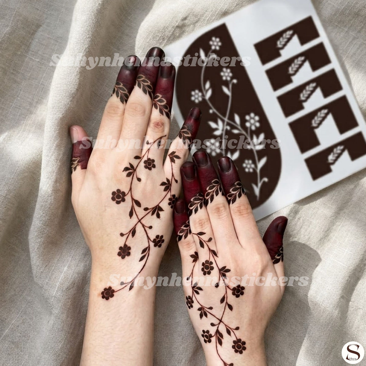 Minimal meadow vine mehendi sticker with delicate floral branches, leafy accents and dark fingertip styling by Suhyn
